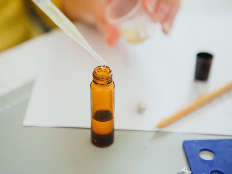 Dropper adding liquid to an amber vial